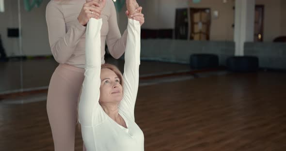 Pregnant Woman and Her Personal Trainer Doing Stretching Exercises