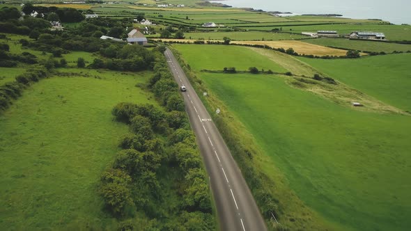 Ireland Roadway Car Driving Aerial View: Green Fields, Meadows, Farmland, Cottages of Antrim County