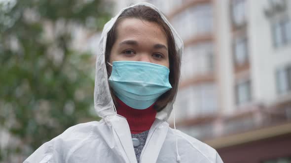 Closeup Portrait of Confident Caucasian Little Woman in Covid19 Face Mask Looking at Camera Standing