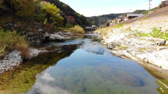 small village in the mountains with a river running through in autumn