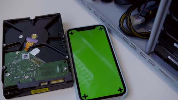 A New Hard Drive on a White Desk Next to a Modern Smartphone