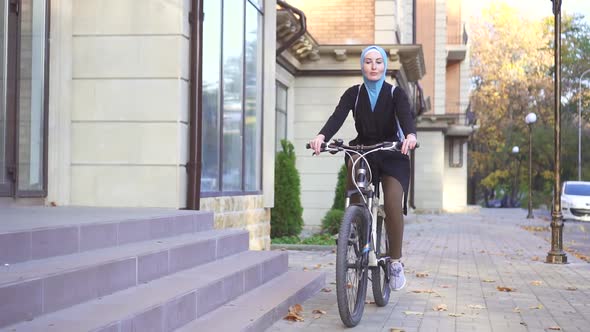 Young Muslim Woman in Hijab Riding a Bike