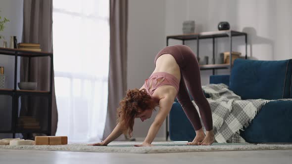 Woman is Practicing Downwardfacing Dog Asana in Room of Apartment Adho Mukha Shvanasana Doing