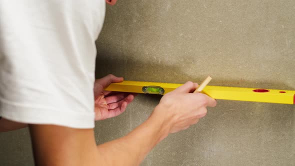 Man Builder Using Balance Ruler and Drawing Line Closeup