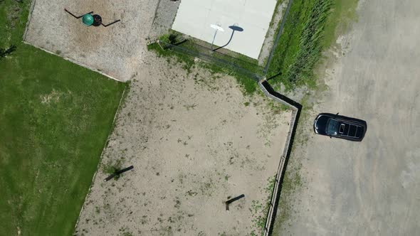 Kids play basketball near playground and mini putt summer camp, overhead aerial