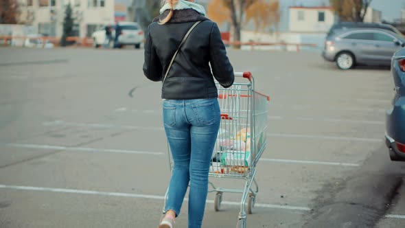 Bayer With Shopping Cart Trolley On Supermarket. Woman Shopper Walking Shopping Cart On Parking.