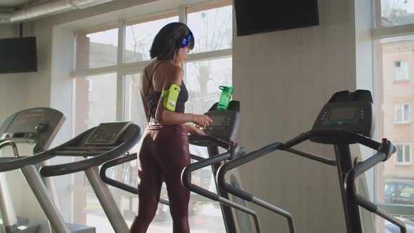 Black Fit Female Doing Cardio Workout on Treadmill