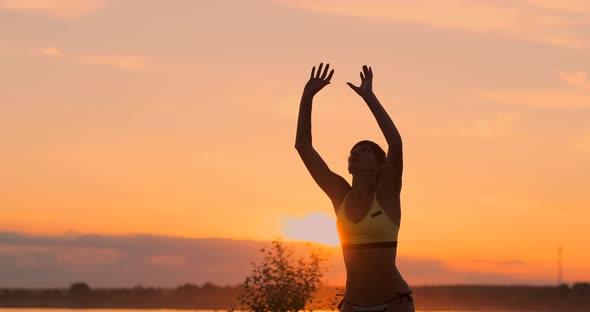 SLOW MOTION, LOW ANGLE, CLOSE UP, SUN FLARE: Athletic Girl Playing Beach Volleyball Jumps in the Air