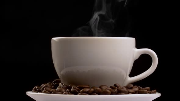 Rotating Shot of Coffee Cup with Steam and Coffee Beans. Slow Motion, Black Background