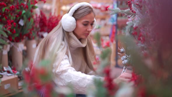Christmas Shopping European Woman Choose Branches for Christmas Wreath Indoor in Supermarket