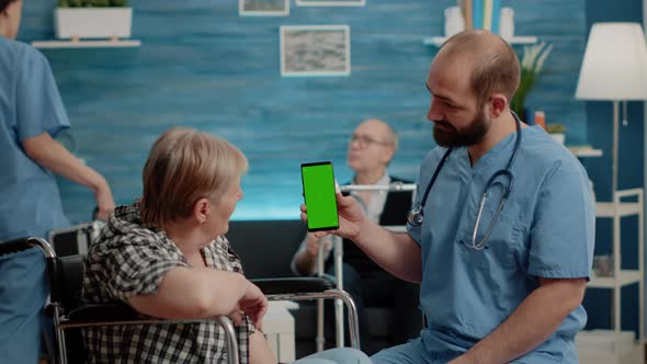 Nurse Vertically Holding Smartphone with Green Screen