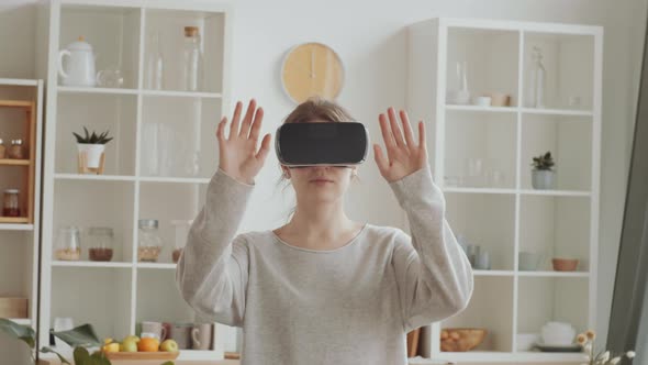 Woman Experiencing Augmented Reality in VR Headset at Home