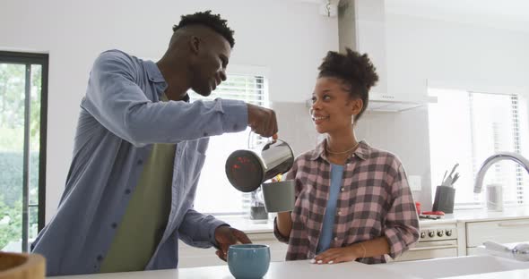 Video of happy african american couple preparing coffee at home