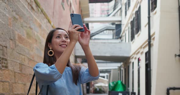 Woman tourist visit Hong Kong city and take photo on phone