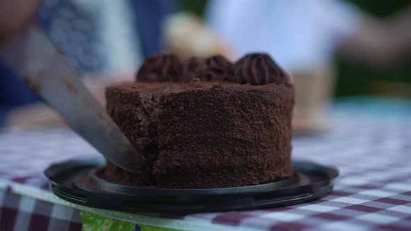 Closeup Slicing Chocolate Cake in Slow Motion with Knife