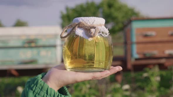 Beekeeper with honey. A woman farmer shows honey from her apiary