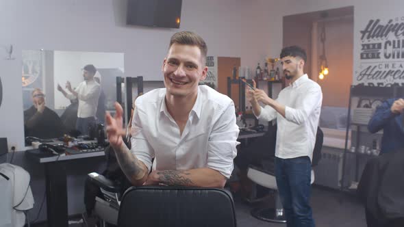 Smiling Barber with Scissors in Hand Smiling at Camera