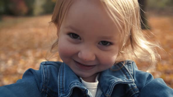 Extreme Close Up Of Happy Little Blond Girl In Fall Season alt