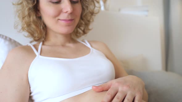 Smiling Pregnant Woman Resting In Bed. Closeup