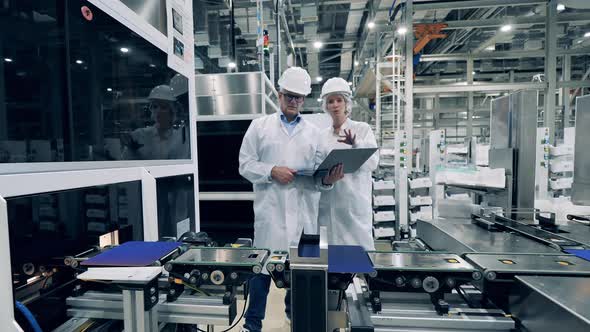 Two Experts are Observing Robotized Conveyor with Solar Cells