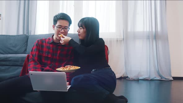 Happy Young Couple Watching Movies on the Laptop or Browsing Social Media with Snack