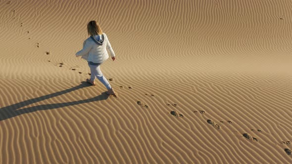  Slow Motion Aerial View of Woman Walking By the Peak of Sand Dune, USA Nature