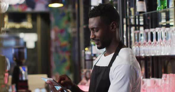 African american barista using tablet smiling in cafe