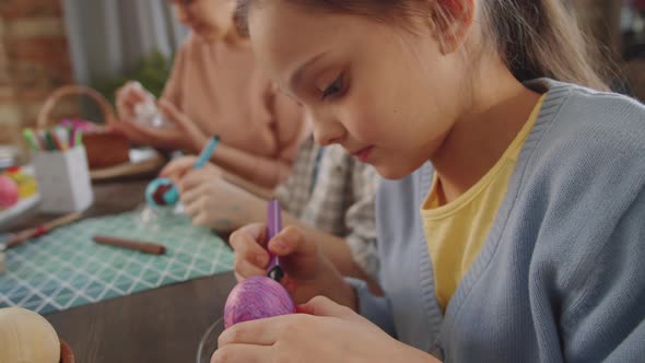 Pretty Girl Drawing on Easter Egg with Marker Pen