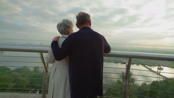 Mature Couple Standing on Terrace Hugging and Looking on City Beauty