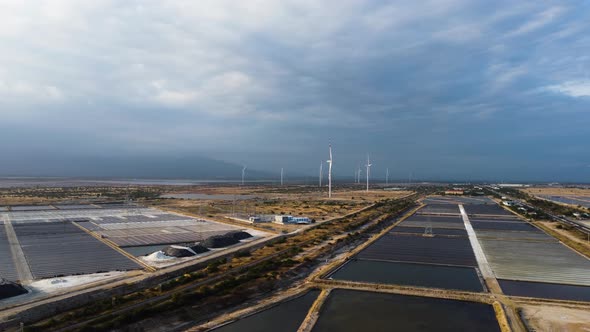 Salt fields and wind turbines. Aerial circular view