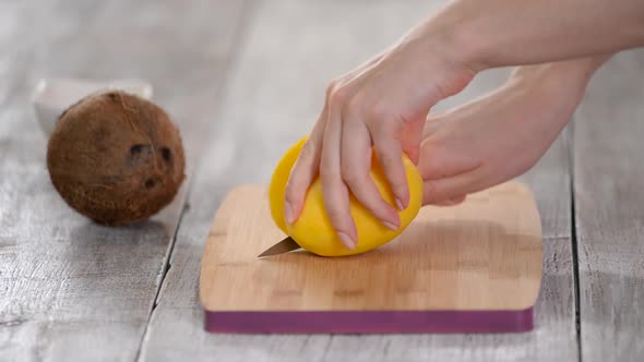 Closeup of woman cutting mango