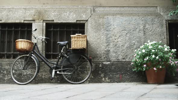 Bicycle and flowers next to a building in Milan Italy.