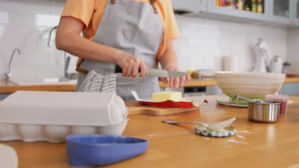 Young Woman with Butter Cooking Food on Kitchen