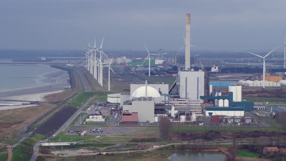 Aerial view of nuclear power plant, wind turbines in background; Borssele