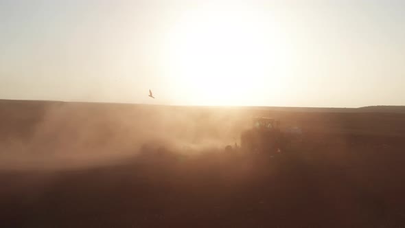 Red Tractor plowing a large field, Early morning follow footage.