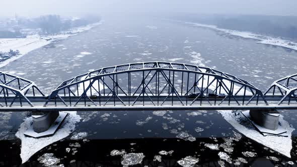 Bridge and river with floes. Transport in winter. Aerial view