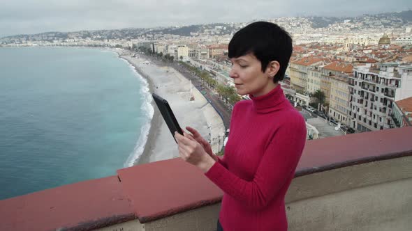 Woman Using Touch Screen Tablet in the Mediterranean City.