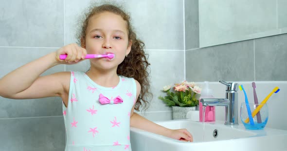 Portrait Happy Cute Young Child Brushing Teeth in Bathroom and Smiling