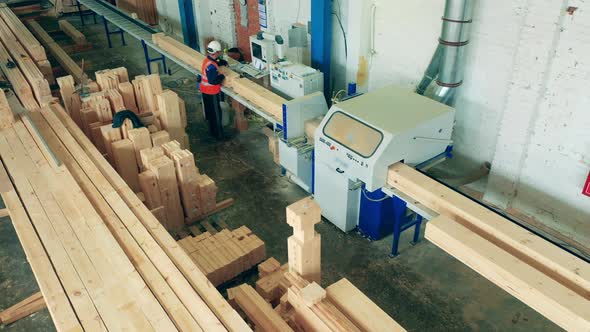 A Man Works in Woodworking Facility with Timber.