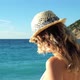 Young beautiful girl in hat and sunglasses standing on beach at sunset - VideoHive Item for Sale