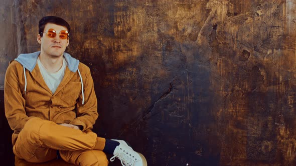 Young Handsome Man in Glasses Sitting on Chair and Looking on Camera