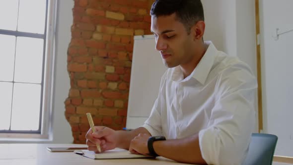 Businessman using smartwatch and digital tablet at desk in modern offic 4k