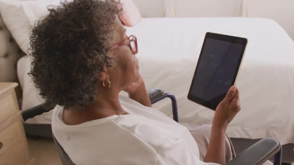 Senior mixed race woman using a digital tablet. Social distancing and self isolation in quarantine