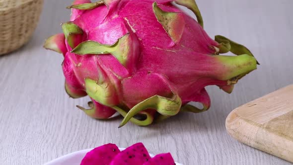  Whole and pieces fresh red dragon fruit, pitahaya, close up at a plate 