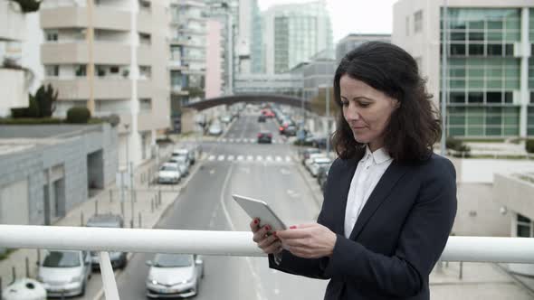 Businesswoman Using Tablet Pc on Bridge