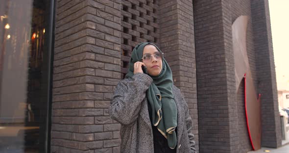 Muslim Woman in Veil Talking By Phone Outdoors