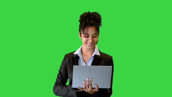 Black Curlyhaired Employee Holding a Laptop on a Green Screen Chroma Key