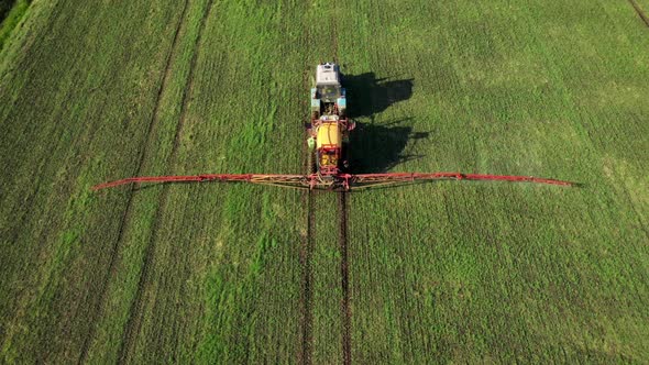 Farm Tractor Spraying Herbicides And Pesticides Fertilizer On Rural Field