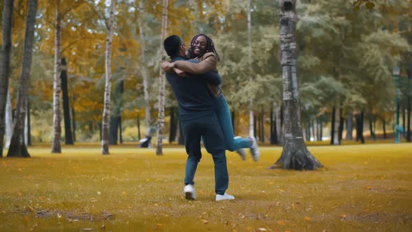 Young Diverse Couple in Love Embracing Standing in Beautiful Autumn Park