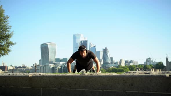 Slow motion shot of man doing push-up in city